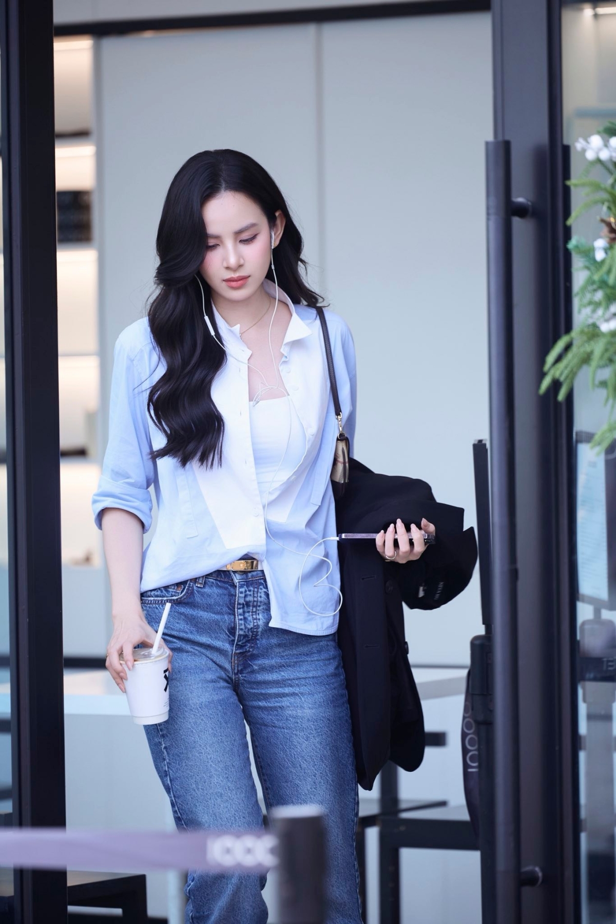 Người đẹp kết hợp sơ mi mở bung cúc cùng áo hai dây, quần jeans ôm dáng. Loạt phụ kiện đi kèm đều là hàng hiệu cao cấp.