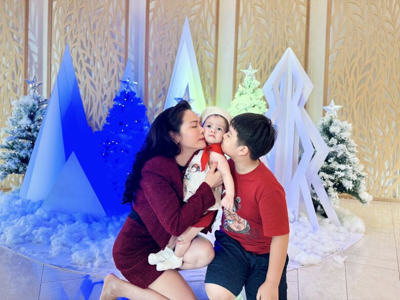 Cô bé được mẹ và anh trai hết mực cưng nựng.