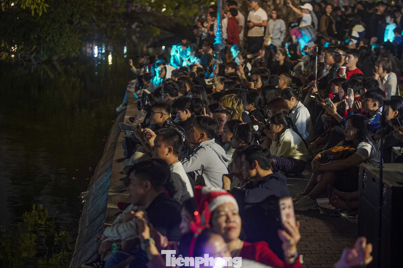 Người dân và du khách ngồi chật cứng hai bên bờ kè để tận hưởng bữa tiệc ánh sáng.