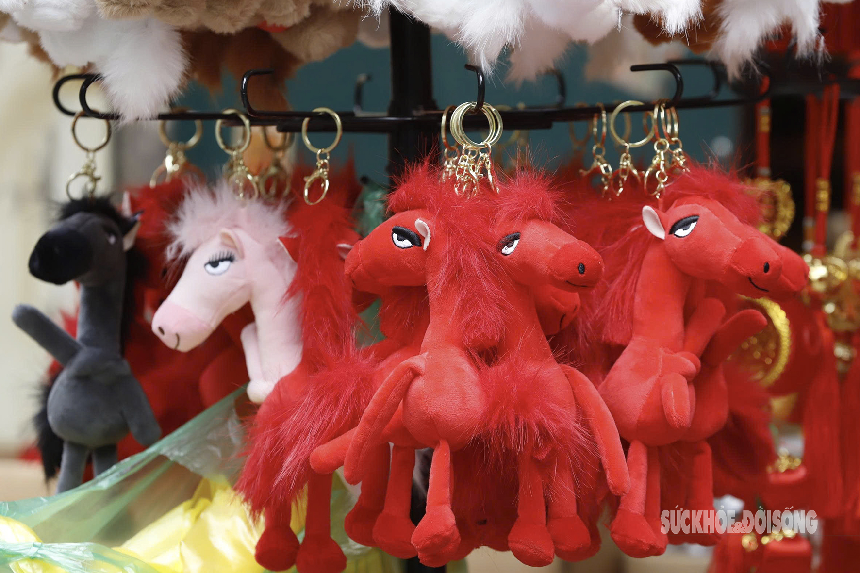Móc khóa thú bông tạo hình ngựa kiểu chibi, màu sắc rực rỡ, được treo thành từng dãy để khách dễ chọn mua.