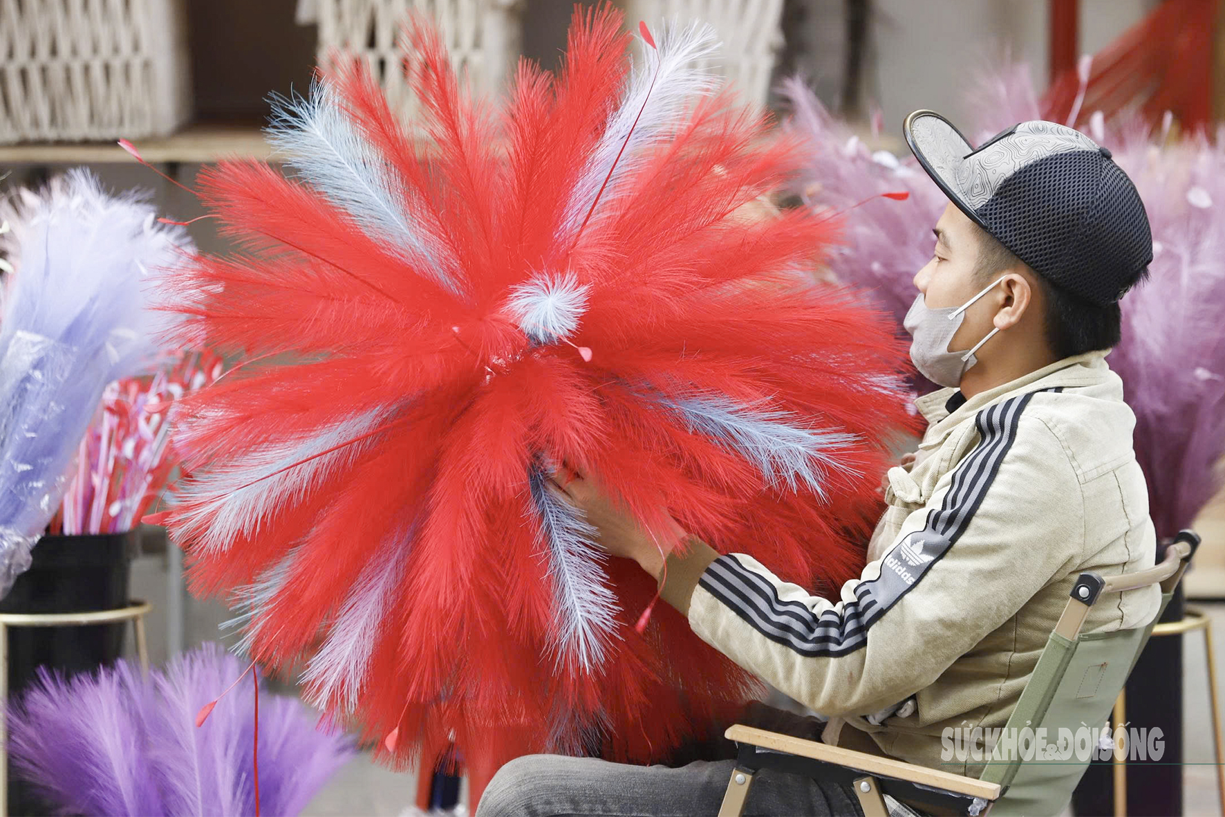 Tiểu thương ngồi hoàn thiện bó trang trí lông vũ khổ lớn, hàng làm liên tục để kịp nhu cầu tăng cao dịp cận Tết.