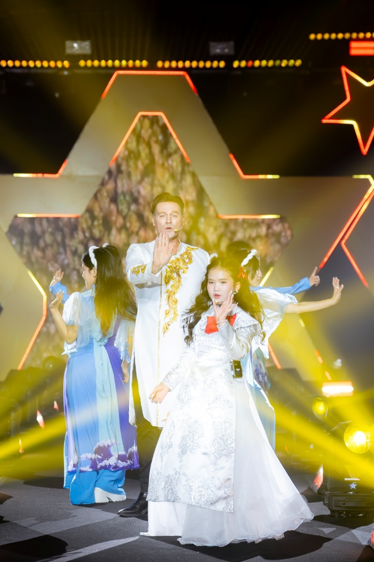 Phong thái biểu diễn tự nhiên cùng giọng hát sáng của nữ ca sĩ nhí giúp tiết mục mở màn tạo ra không khí trang trọng và tích cực cho toàn bộ sự kiện.