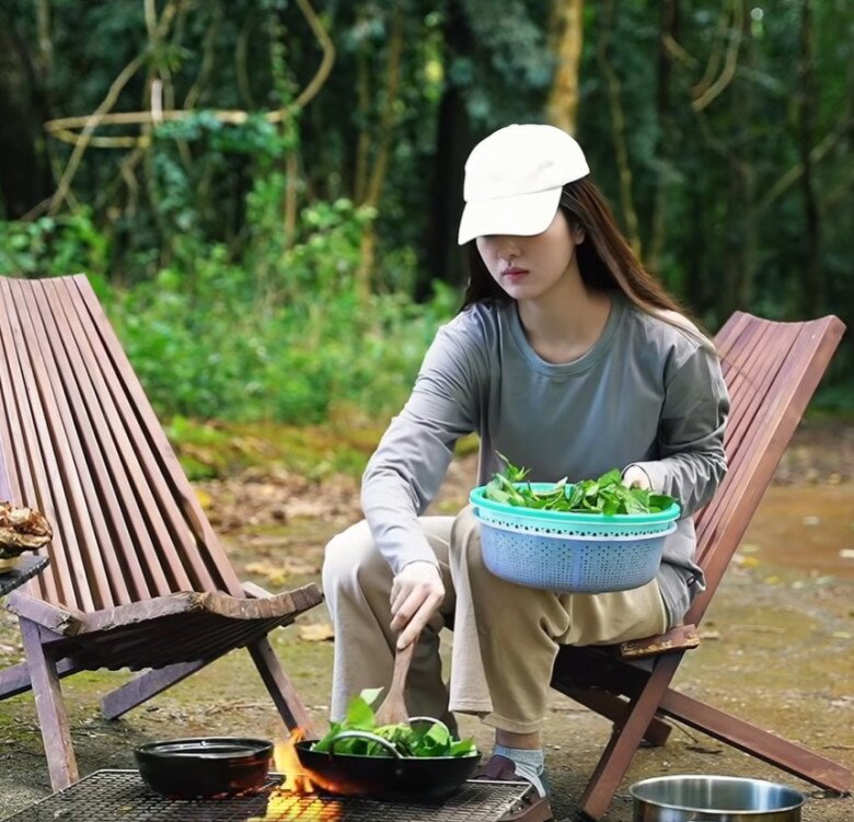 Trong khi chồng phụ trách món chính, vợ anh cũng không kém phần đảm đang khi chuẩn bị rau xào và cá kho cho bữa cơm ngoài trời.