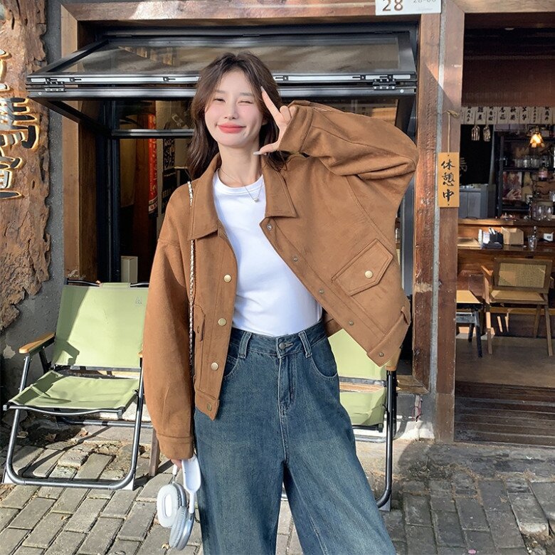 Áo khoác dáng ngắn phom boxy màu caramel, gam màu ấm áp tạo cảm giác gần gũi, dễ ứng dụng trong đời sống hằng ngày và hài hòa khi kết hợp cùng áo thun trắng và quần jeans xanh.