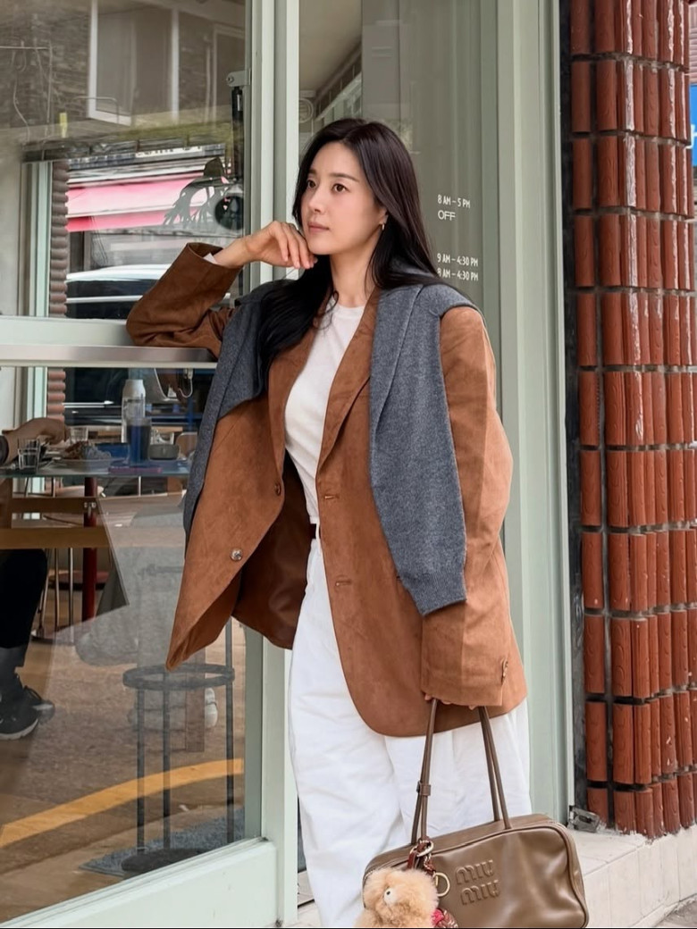 Set đồ mang hơi thở cổ điển với áo khoác màu caramel chất liệu da lộn. Gam màu ấm áp kết hợp cùng áo trắng và quần sáng màu giúp tổng thể trở nên thanh lịch, nhã nhặn, rất phù hợp với phong cách thu đông.