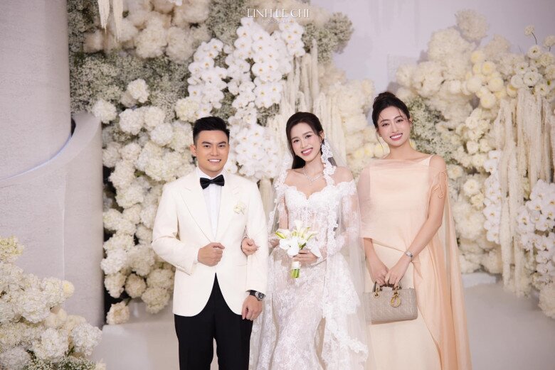 Hoa hậu Lương Thùy Linh khoác lên mình bộ váy lụa hồng kem phối thêm khăn choàng cùng tông màu tạo nên vẻ sang trọng mà vẫn giữ được sự tinh tế, nhẹ nhàng. Thiết kế này thuộc về thương hiệu Việt có giá hơn 2 triệu đồng. Nàng hậu xách theo chiếc túi Dior Lady màu xám nhạt có giá hơn 100 triệu.