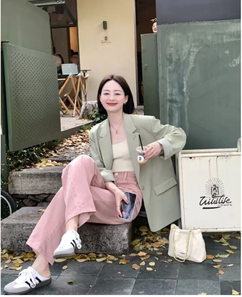Chiếc blazer xanh bạc hà khoác ngoài áo hai dây kem và quần hồng pastel tạo nên sự cân bằng tuyệt vời giữa mát lạnh và ấm áp.