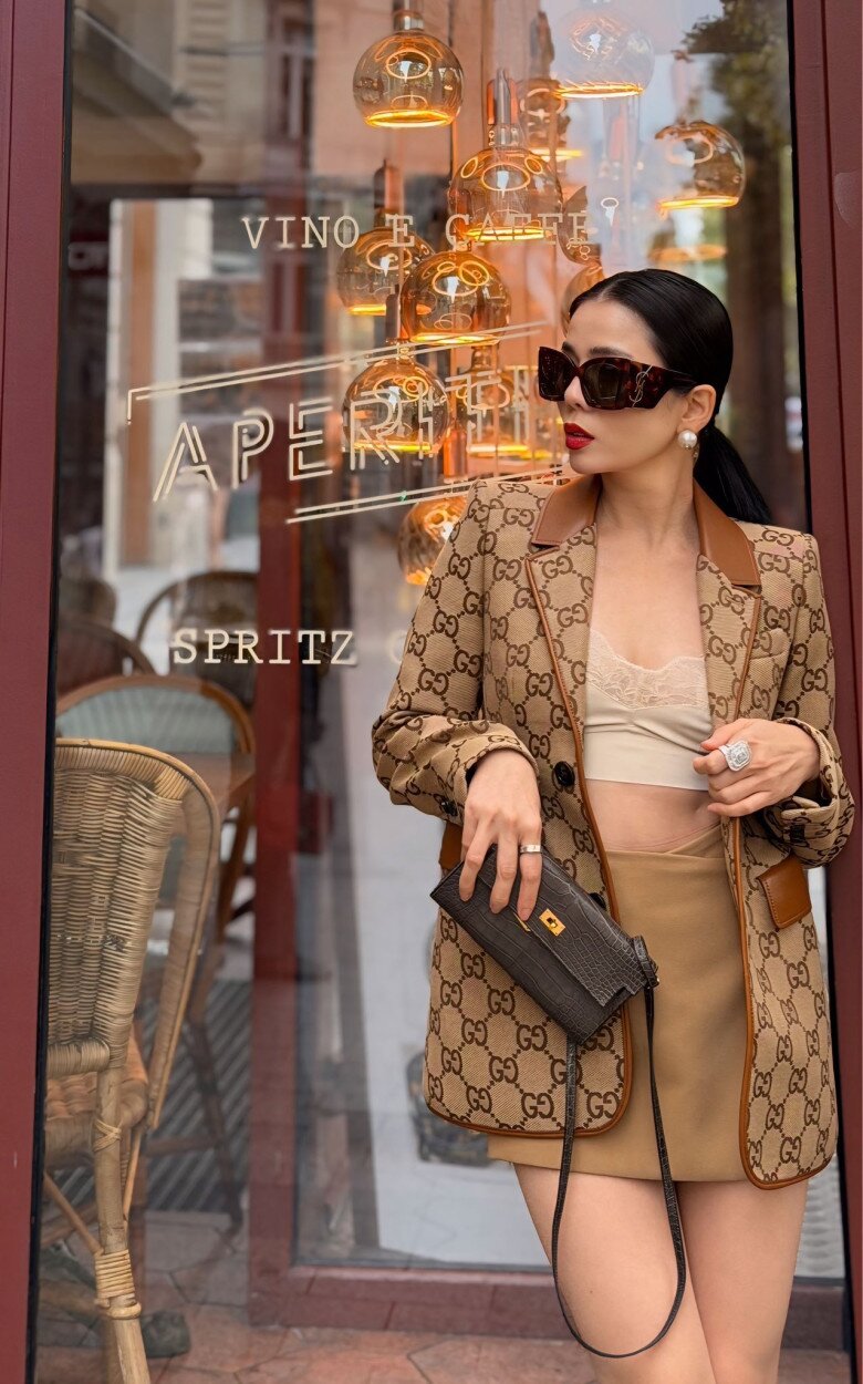 Cô mix áo khoác xa xỉ cùng áo bralette ren và chân váy mini đồng điệu, khoe khéo vòng eo thon cùng đôi chân nuột nà.