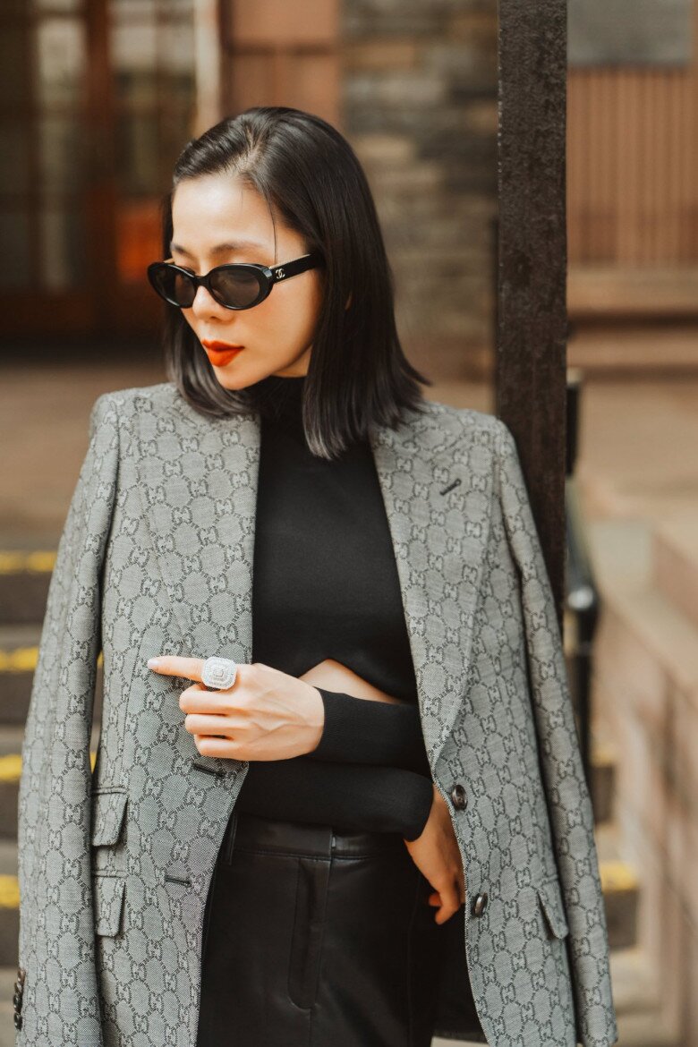 Diện blazer Gucci tông xám họa tiết monogram cổ điển có giá hơn 90 triệu đồng, Lệ Quyên khoe trọn thần thái của một fashionista thành thị. Cô phối cùng áo len đen cut-out tinh tế và chân váy da, tạo nên sự giao thoa giữa cổ điển và hiện đại.