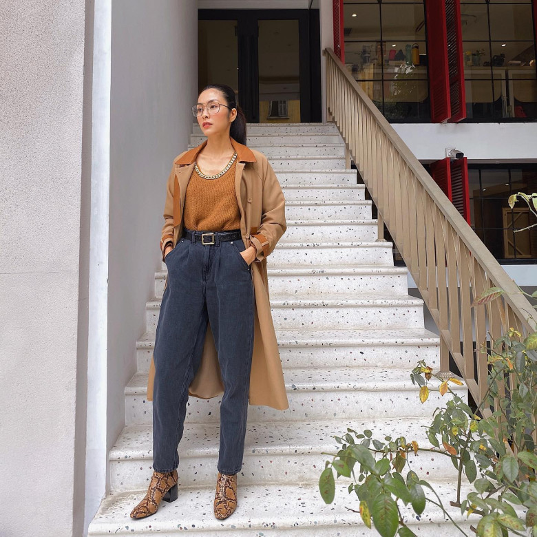Tăng Thanh Hà phối áo len màu camel ton-sur-ton cùng trench coat dáng dài, tạo nên lớp layering cổ điển nhưng hiện đại. Cô diện cùng quần denim cạp cao phom suông, nhấn bằng thắt lưng bản vừa để định hình vòng eo. Đôi boots họa tiết da rắn trở thành điểm nhấn thời thượng, nâng tầm tổng thể một cách tinh tế mà không cần phô trương.