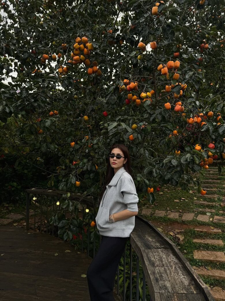 Mỹ nhân 8x chọn bảng màu xám và đen để làm bật lên vẻ tối giản hiện đại. Áo nỉ xám có phom dáng lửng rộng, kết hợp quần ống suông đen tạo dáng vẻ thon gọn. 