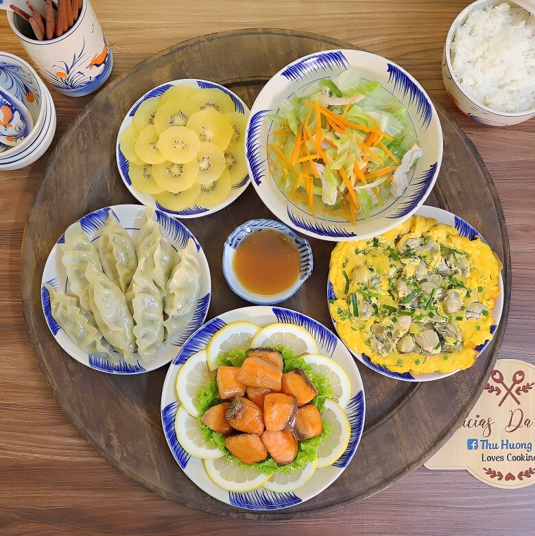Mâm cơm này gồm các món: Cá hồi sốt chanh, trứng chiên hàu, bánh mandu, canh bắp cải.