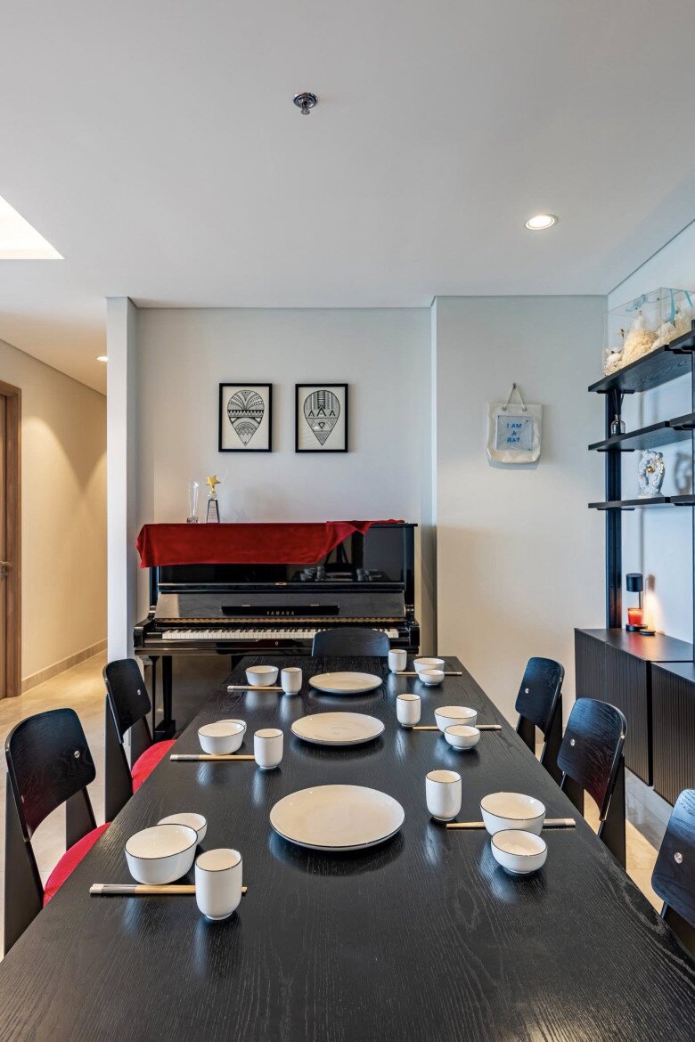 Phòng ăn kết hợp không gian âm nhạc với đàn piano đen và dàn bàn ghế đệm đỏ nổi bật. Kệ treo tường với nhiều món decor nhỏ như tượng hổ, lọ gốm… mang màu sắc cá nhân. Á hậu hào hứng với cảnh bé Ayla sẽ tập ăn dặm trên chiếc bàn này.