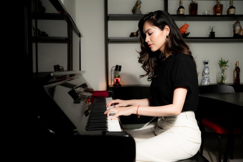 Á hậu chơi đàn trong không gian riêng tư, ấm cúng. Góc đàn piano được đặt ngay cạnh giá sách và kệ rượu, cho thấy sự đầu tư chỉn chu cả về thẩm mỹ lẫn cảm xúc trong không gian sống. Hoàng My bày tỏ: Em sinh ra ở Áo - cái nôi âm nhạc, một ngày em đánh piano cho mẹ nghe nhé.