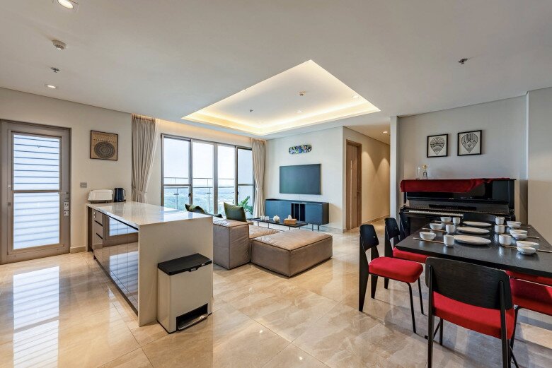 Từ cửa bước vào nhà nhìn thấy ngay bàn đảo bếp và phòng khách. Nội thất theo phong cách tối giản, hiện đại. Sàn gạch bóng, bếp đảo đá trắng kết hợp cùng ghế sofa lớn màu da bò tạo cảm giác rộng rãi mà ấm cúng.