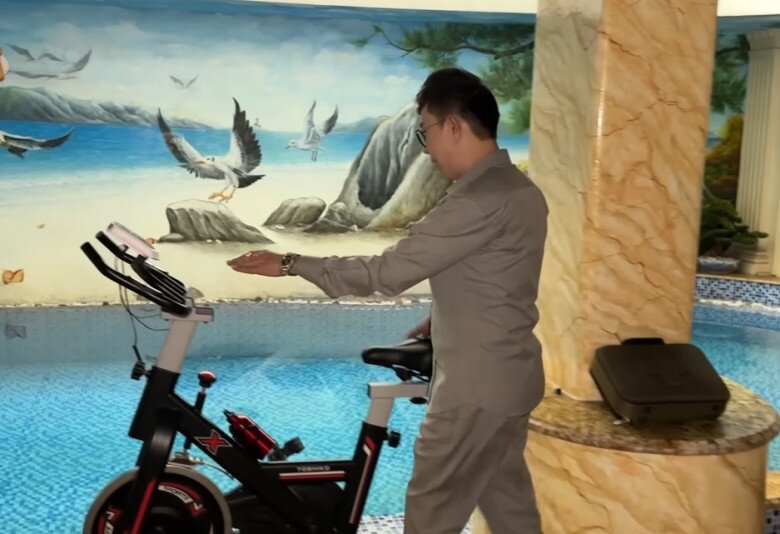 Khu vực bể bơi trong nhà có tranh tường biển, ánh sáng nhân tạo mô phỏng không gian ngoài trời, đi kèm xe đạp tập thể dục tạo nên không gian đầy thư giãn.