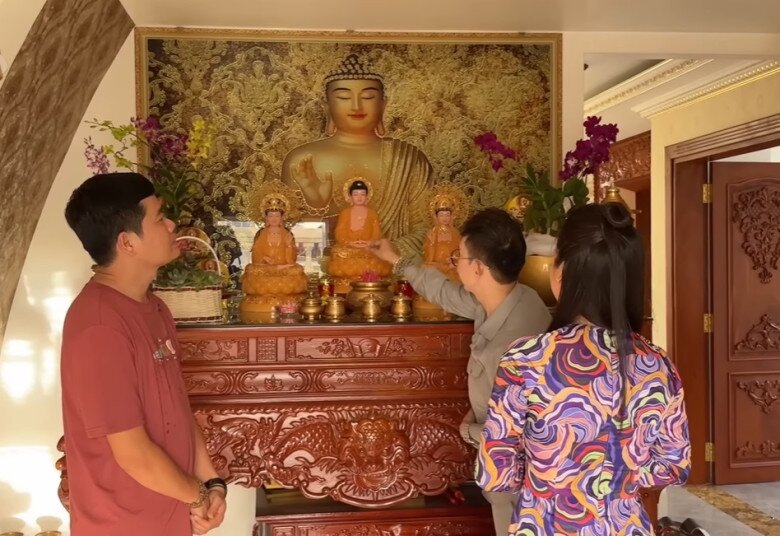 Gian thờ Phật ở tầng trên, bài trí trang nghiêm với bàn thờ gỗ chạm rồng, tượng Phật và bình hoa.