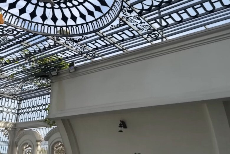 Mái vòm kính trên sân thượng với khung sắt nghệ thuật, đón nắng, che mưa, đồng thời làm giàn treo cây leo.