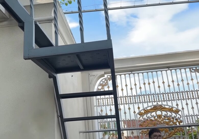 Thang sắt dẫn lên khu vườn rau và cây trái trên mái, cho thấy sự chăm chút và tận dụng từng mét vuông của ngôi nhà.