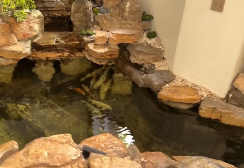 Khu vực tiểu cảnh với hồ cá Koi và hòn non bộ trong nhà, tạo nên một không gian thư giãn, gần gũi thiên nhiên.