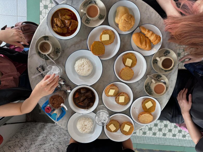 Một buổi tụ tập của anh chàng cùng những người bạn với bàn ăn đầy ắp món ngon: Cơm trắng ăn kèm cà ri gà và bò kho, bánh mì nướng bơ vàng, bánh mì ngọt, croissant và đồ uống.