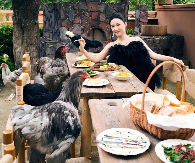 Hoắc Tư Yến dùng bữa ngoài trời cùng gà – một khung cảnh hiếm thấy trong giới sao Hoa ngữ. Chiếc bàn gỗ dài đặt giữa sân vườn, thực đơn đơn giản nhưng ấm cúng, gợi cảm giác đồng quê gần gũi.