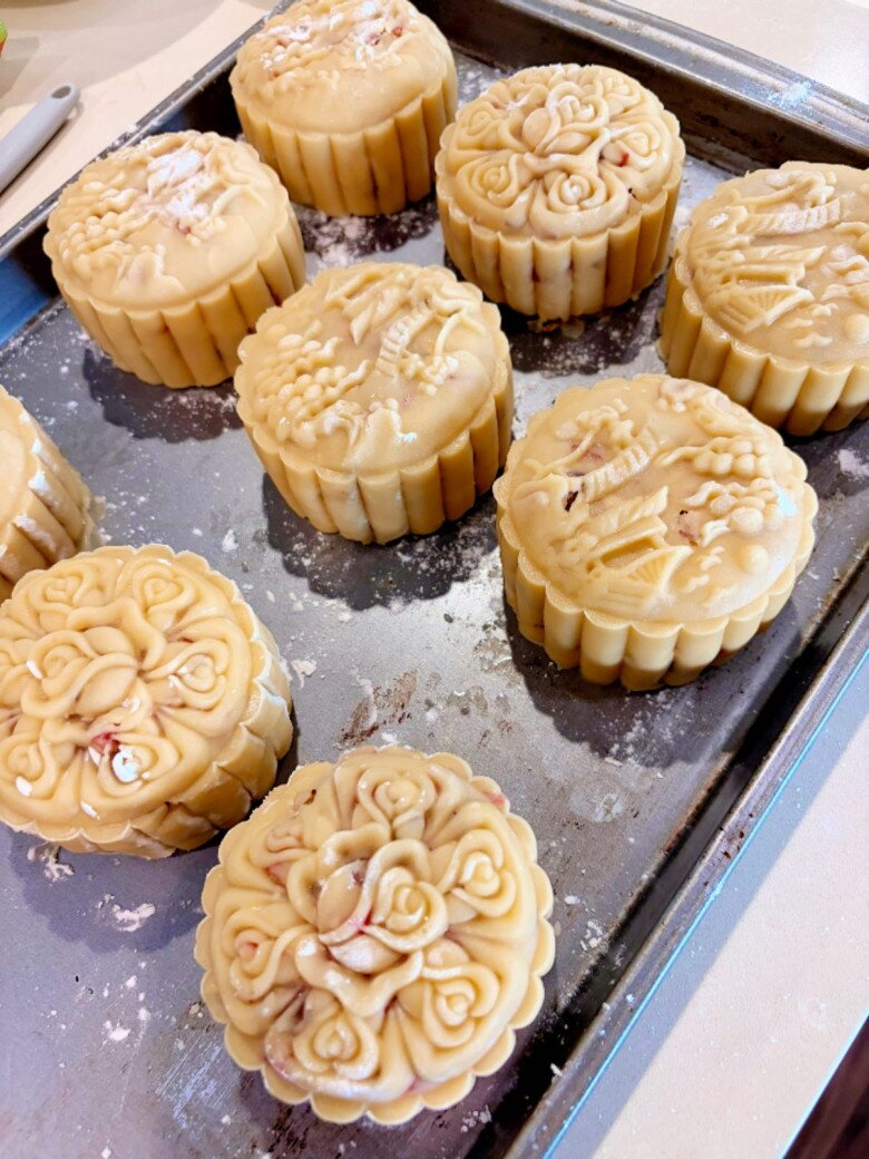 Những chiếc bánh Trung thu thập cẩm trước khi mang đi nướng được tạo hình hoa văn tinh xảo. Vỏ bánh vàng tươi, đều màu, từng họa tiết được dập sắc nét thể hiện sự khéo léo của người làm.