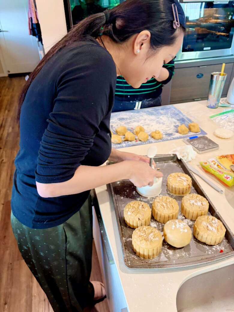 Mọi người trong nhà cùng xắn tay áo vào bếp, tự tay đóng khuôn cho từng chiếc bánh. Không khí trong căn bếp rộn ràng, đầy yêu thương.