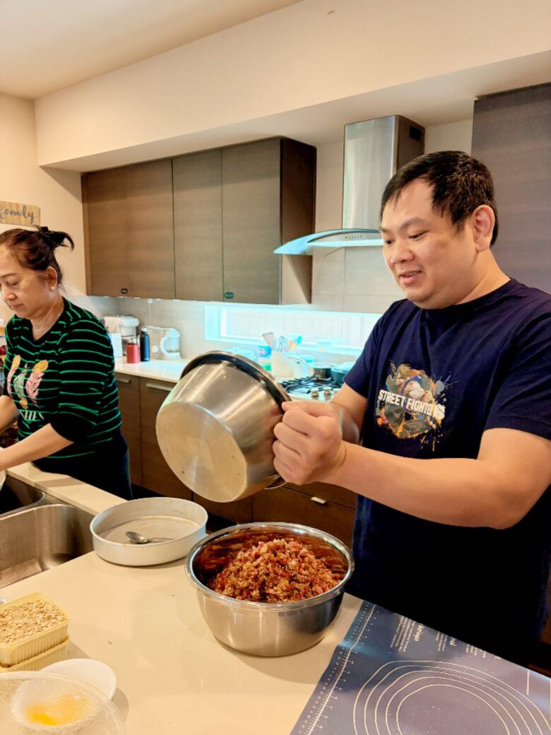 Một thành viên khác hào hứng phụ trách phần trộn nhân – công đoạn quan trọng quyết định hương vị bánh. Nhân bánh thập cẩm được trộn đều tay, nêm nếm đậm đà theo công thức lâu năm.