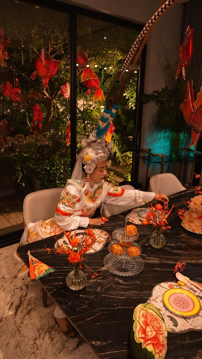 Á hậu Ngô Thùy Linh hóa thân thành nhân vật hát bội, bày bánh và chuẩn bị đón các thượng khách trong không gian lung linh ánh sáng. Không khí lễ hội cũng lan tỏa khắp căn nhà nhờ cách bài trí tinh tế.