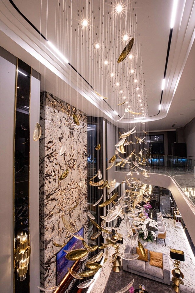 Một góc nhìn từ trên cao xuống cho thấy toàn cảnh phòng khách và bàn ăn, nổi bật với đèn trần thiết kế nghệ thuật và không gian mở hiện đại, đậm chất châu Âu.