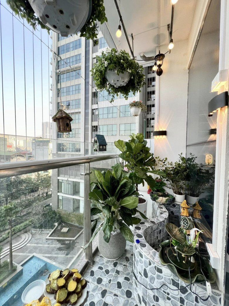 Không gian ban công được lát gạch giả sỏi, đặt các bồn cây lớn và bệ tiểu cảnh uốn lượn độc đáo như một dòng suối nhỏ ngay giữa phố thị, có đèn trang trí, bình hoa sen và tượng nhà nấm tinh tế.
