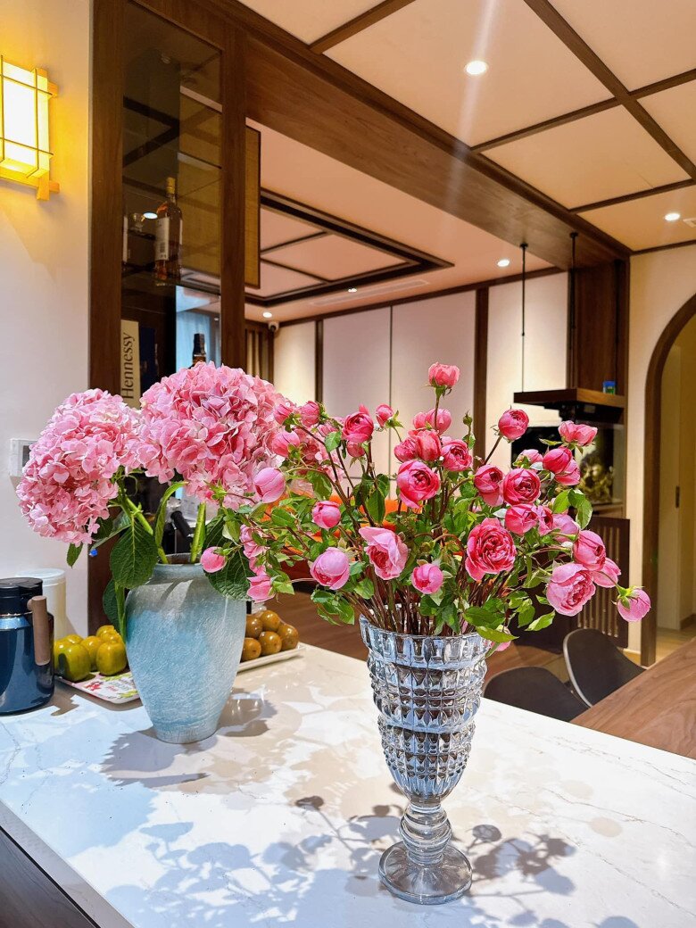 Hoa hồng ngoại được cắm trong bình thủy tinh cao, dáng cổ điển. Thân hoa được tỉa sạch lá phần dưới, cắm chéo để tạo độ xòe tự nhiên. Một vài bông vươn cao tạo điểm nhấn, mang lại bố cục tự do nhưng vẫn cân đối. Đây là kiểu cắm bán tỏa tròn, dễ thực hiện và hợp với không gian hiện đại.