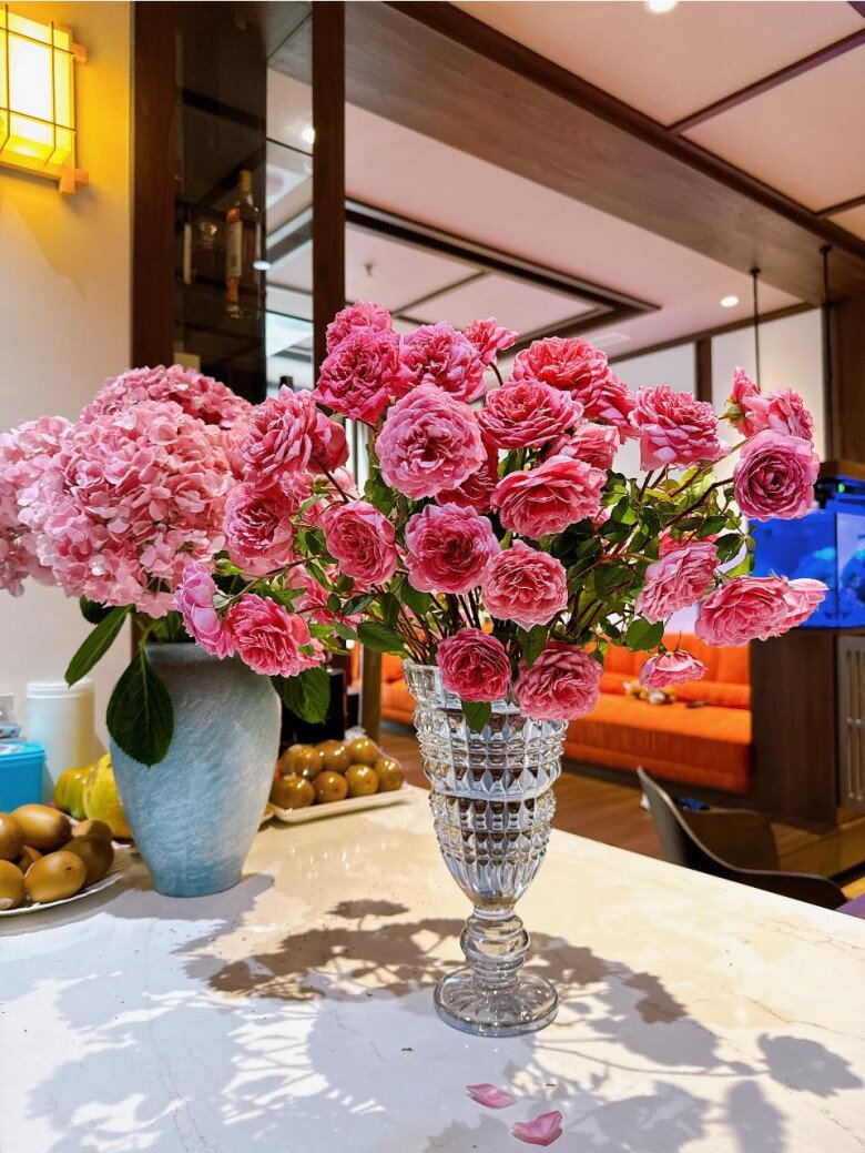 Sáng hôm sau, những bông hồng đã bung nở rực rỡ, tạo thành bó hoa tròn đầy và sống động hơn hẳn. Nhờ được cắm theo kiểu tỏa tròn trong bình thủy tinh cao, mỗi bông có đủ không gian để khoe sắc mà không bị chen chúc, giữ được dáng tự nhiên và độ bền đẹp.