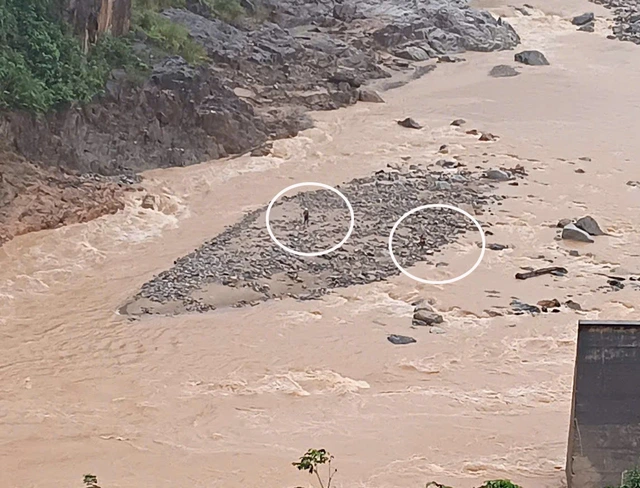 Hai người bị kẹt giữ dòng nước lũ cuồn cuộn.