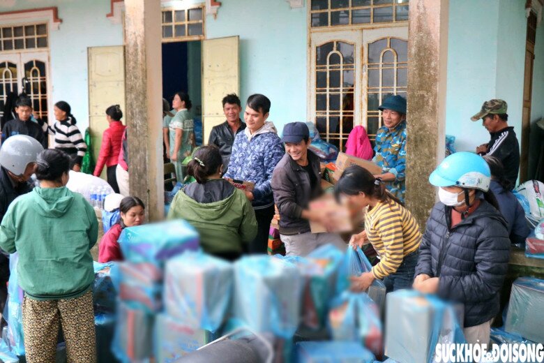 Người dân gói hàng hóa, nhu yếu phẩm để chuyển vào tâm lũ.