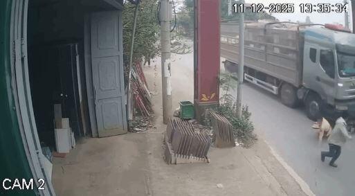 Thời điểm người vi phạm ôm CSGT đẩy vào đầu xe tải. 