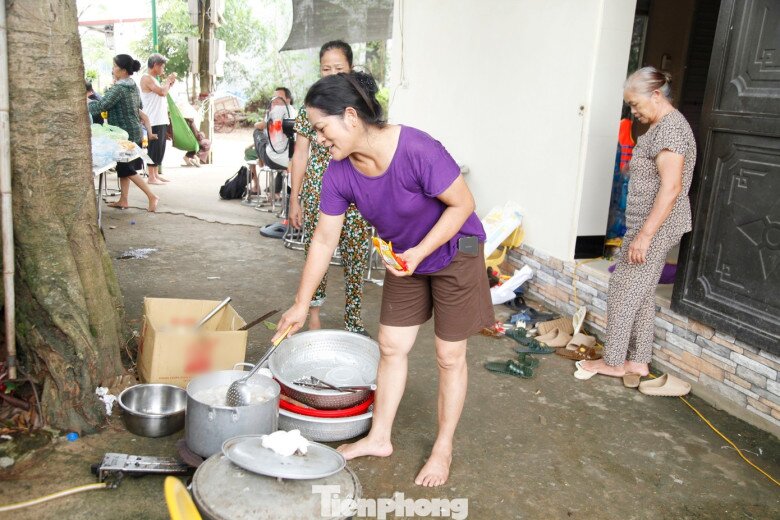 Chị Lương Thị Thuận cùng nấu cơm với người trong thôn. Ảnh: Nguyễn Thắng