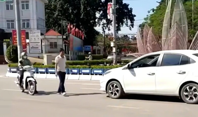 Nam tài xế điều khiển ô tô đi ngược chiều tranh cãi với người phụ nữ đi xe máy. Ảnh cắt từ clip