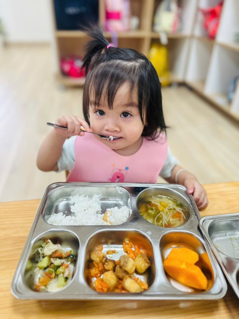 Nhóc tì ngoan ngoãn ăn uống khi ở trường học.