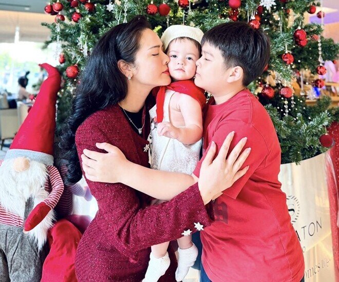 Cô bé được mẹ và anh trai hết mực cưng nựng.