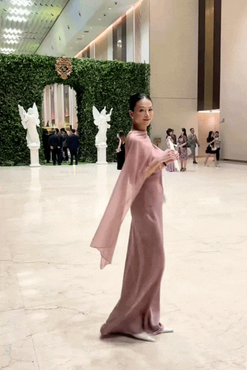 Hoa hậu Phương Khánh toát lên khí chất kiêu sa, quý phái vô cùng khi chọn một thiết kế đầm lụa thướt tha tới dự đám cưới của Tiên Nguyễn. Thiết kế có phom hai dây cổ đổ ôm sát đường cong, đi kèm khăn choàng cổ hững hờ, giúp hoa hậu tôn bờ vai trần, eo thon cùng vóc dáng thanh mảnh.