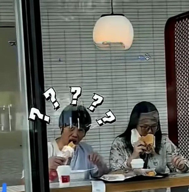 Cả hai cúi mặt vì ngượng khi bị phát hiện, song vẫn ăn tiếp.