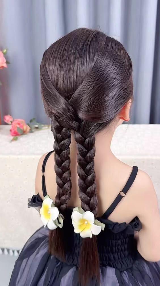 Mẹ chia tóc thành hai phần, sau đó lộn hai phần vào giữa nhau và tết lại như hình.