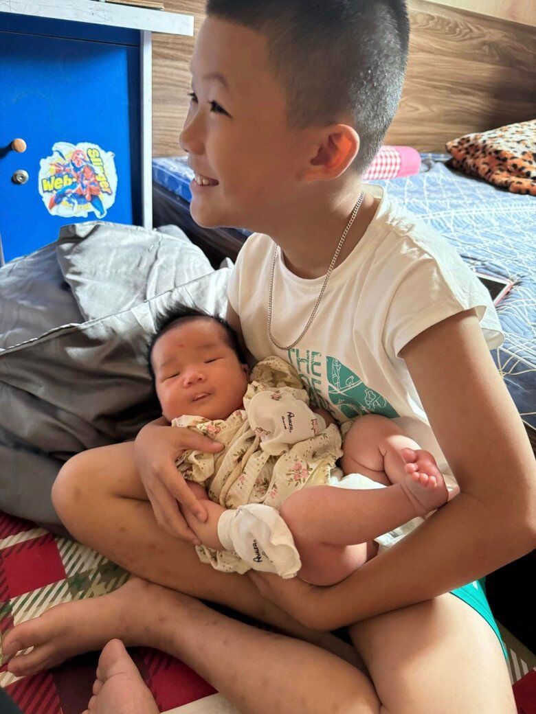 Bé Đông Hải thích thú khi được bế cháu - con của chị gái.