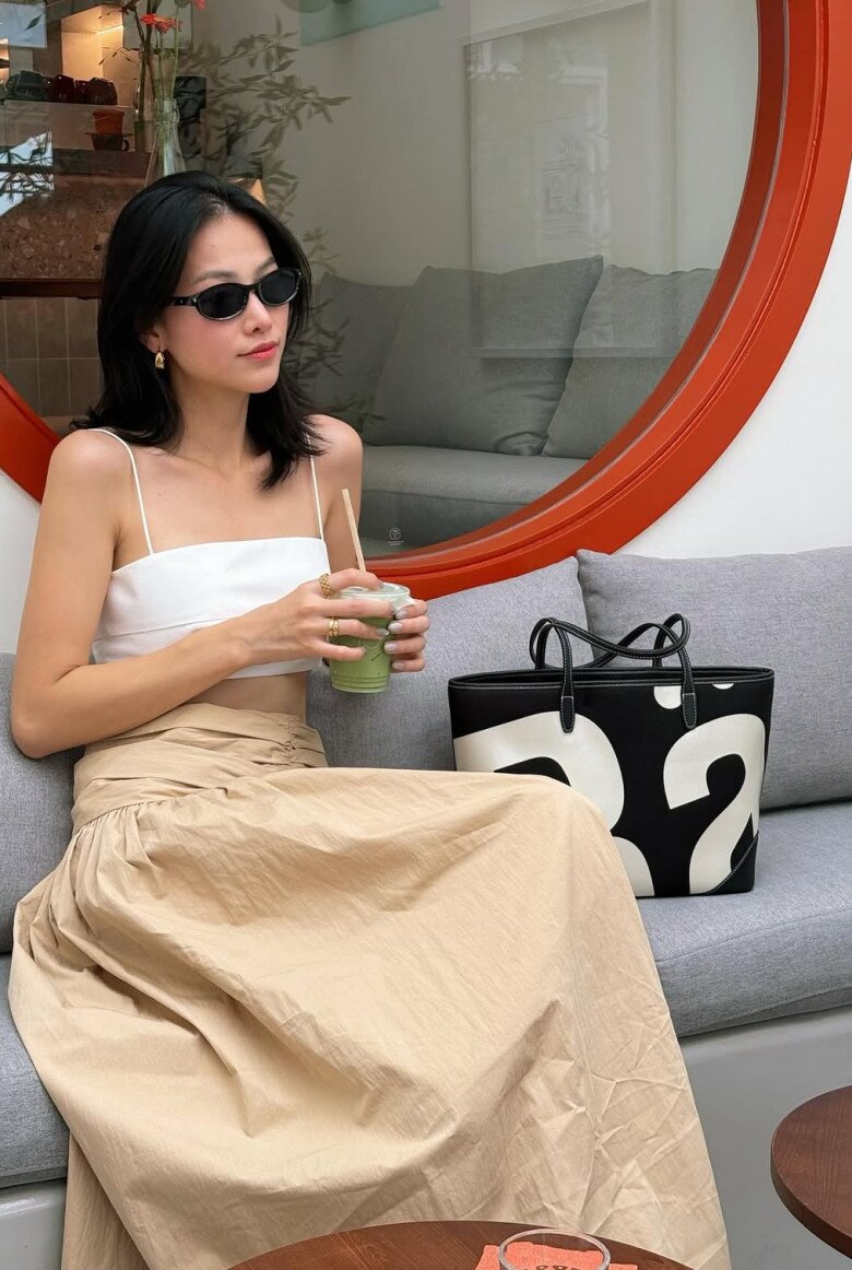 Trong một buổi chiều lãng đãng, Phương Khánh chọn áo hai dây trắng cùng chân váy beige. Tông màu trung tính và chất liệu mềm rủ khiến cô trông như một cô gái Paris giữa Sài Gòn – thanh lịch, nhẹ nhàng mà vẫn đầy sức hút. Chút son môi cam đất, vòng cổ mảnh và ly cappuccino – tất cả hòa vào nhau như một thước phim ngắn về người phụ nữ yêu cái đẹp.
