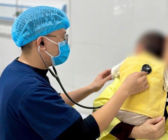 Bác sĩ đang thăm khám cho trẻ mắc cúm A tại Bệnh viện Bệnh Nhiệt đới Trung ương. 