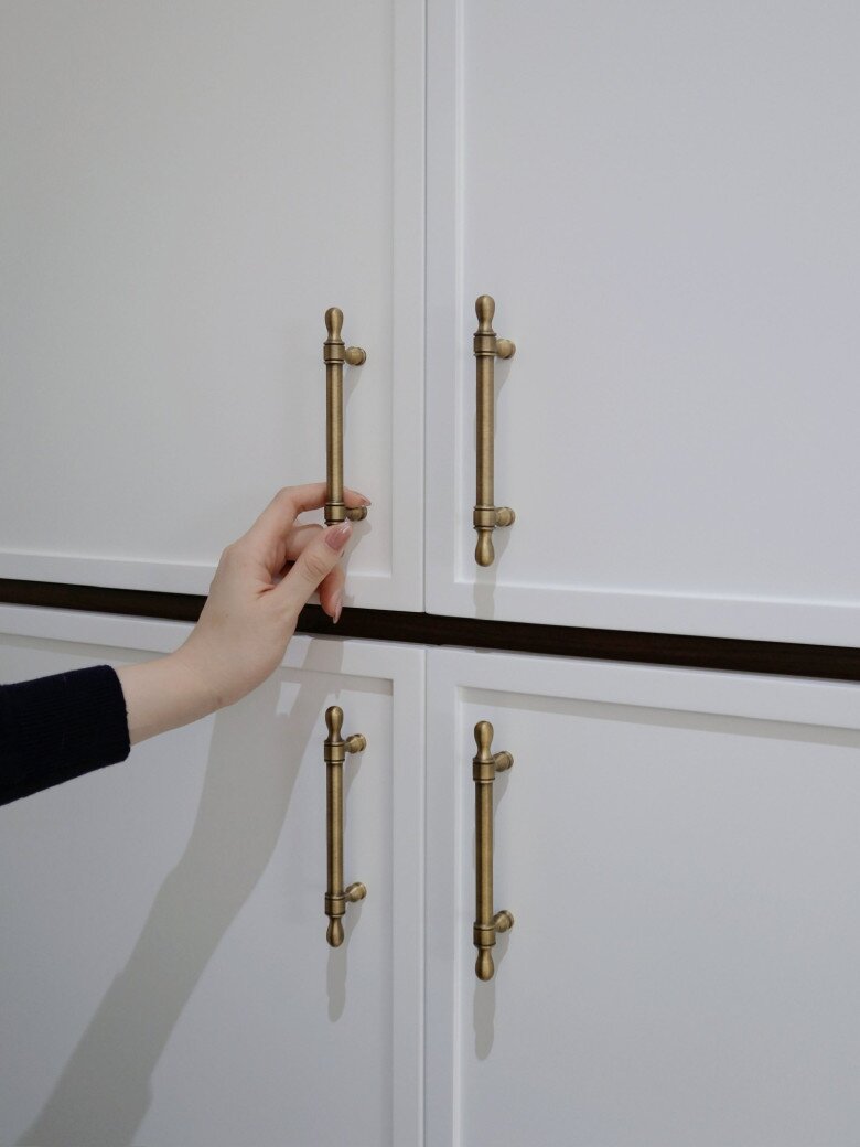 Hệ thống tủ bên dưới được thay bằng màu trắng cho đồng nhất với tủ bên trên và màu sơn nhà. Tủ đều có tay nắm để tiện đóng mở.