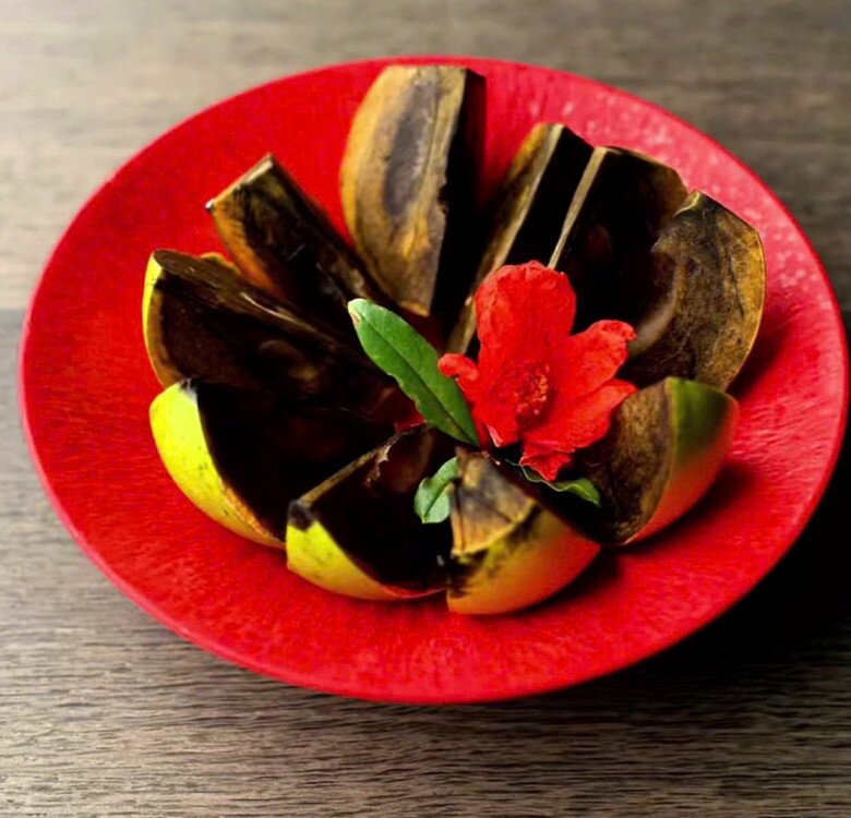 Nữ diva bổ hồng bày ra đĩa và hái một bông hoa lựu đặt lên trên để đĩa trái cây thêm bắt mắt.