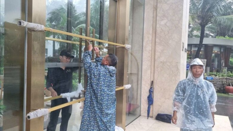 Người dân che chắn cửa, hạn chế va đập khi bão 13 đổ bộ vào đất liền. Ảnh: T.T